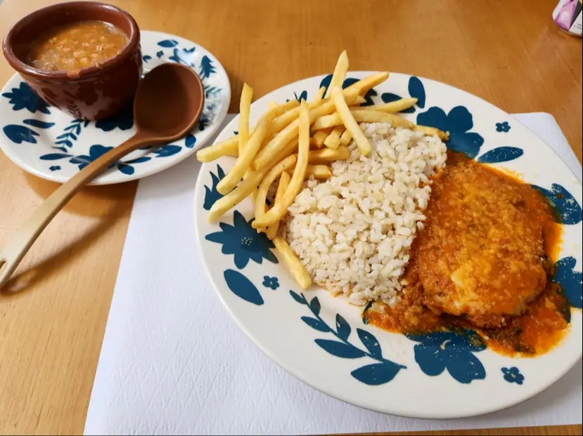 Parmegiana vegana com arroz e fritas no prato azul e branco